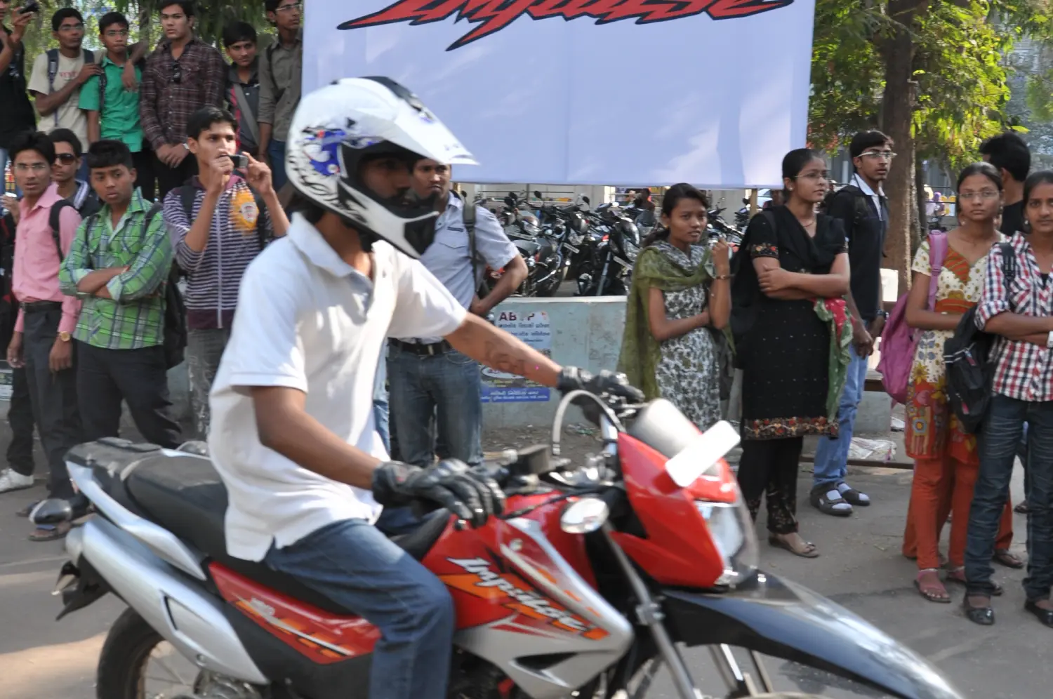 Men lighting ceremonial lamp at event with ITT banner in background